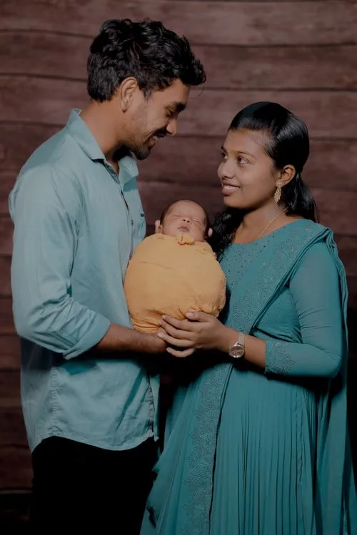 Indian parents holding their newborn at home