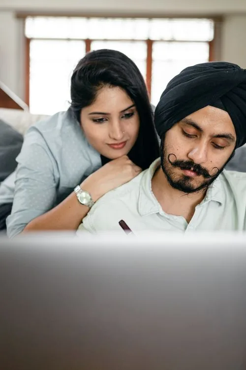Couple using a laptop together in their living room