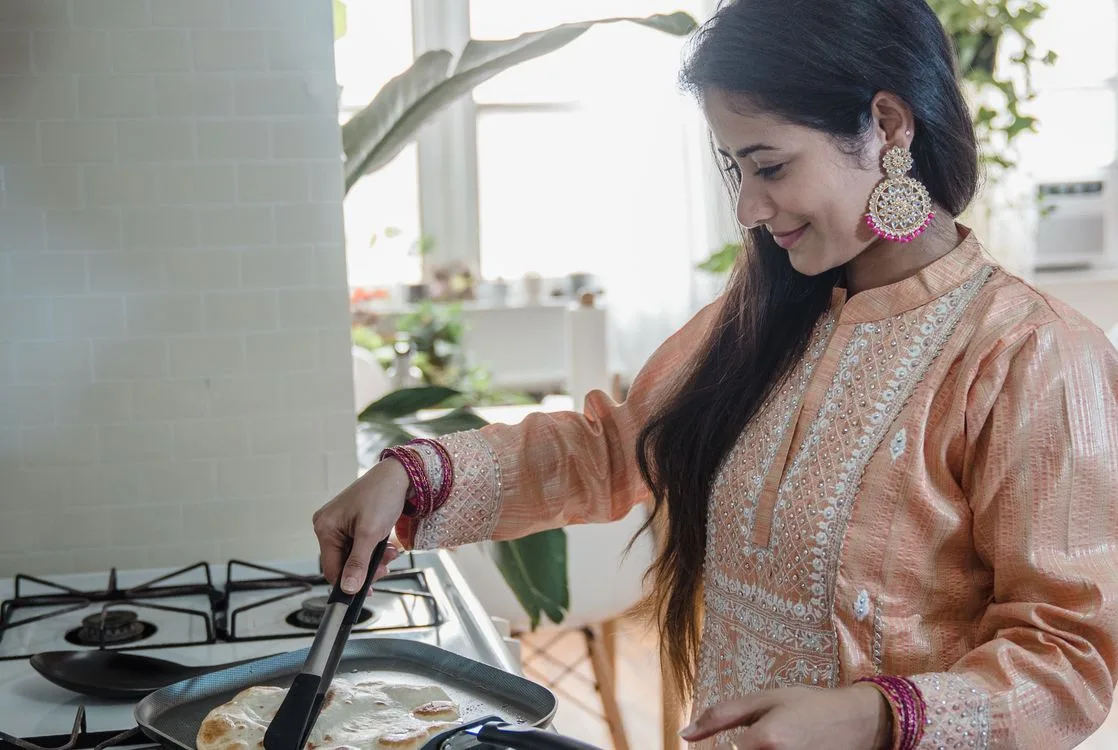 Woman cooking flatbread in a bright home kitchen