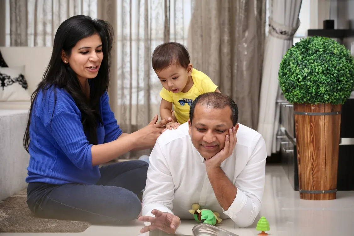 Parents playing with their young child at home